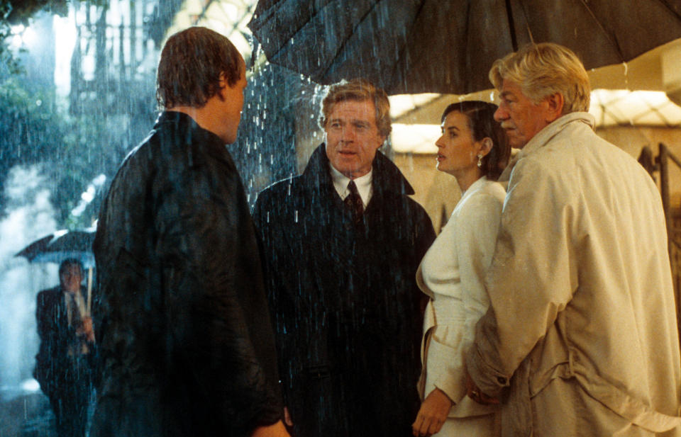 Robert Redford and Demi Moore standing under an umbrella in the pouring rain in a scene from the film 'Indecent Proposal', 1993. (Photo by Paramount Pictures/Getty Images)