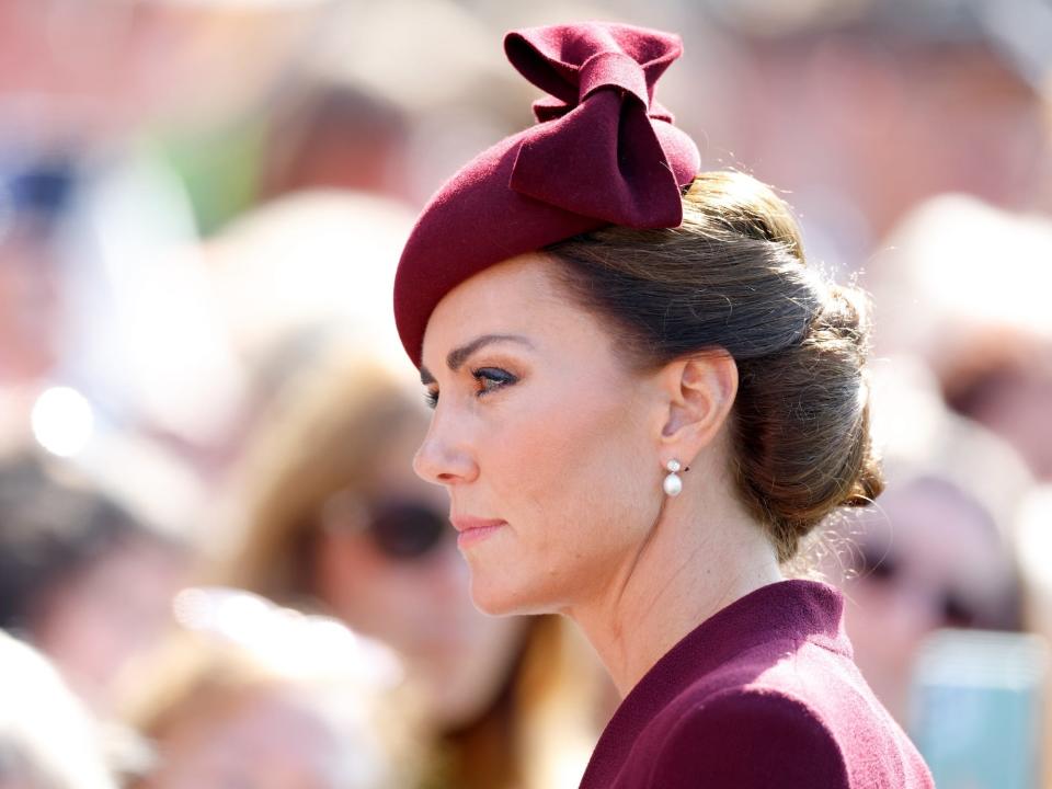 Kate Middleton wearing a deep-red fascinator.