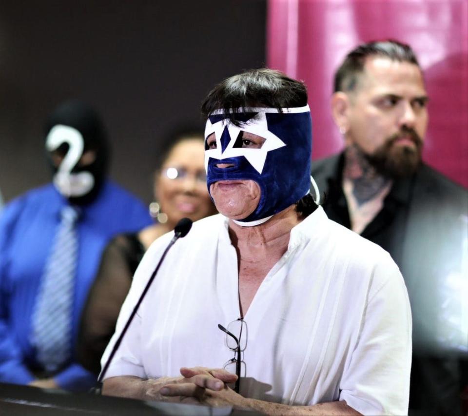 Mexican wrestler Rocky Star (Federico Ramirez) speaks about his induction into the Juárez Lucha Libre Hall of Fame at a news conference at Juárez City Hall, in the background to the left is Serpiente Blanca, in a black mask with a white serpent, who will also join the hall of fame. Popular Juárez wrestler Pagano is on the right.