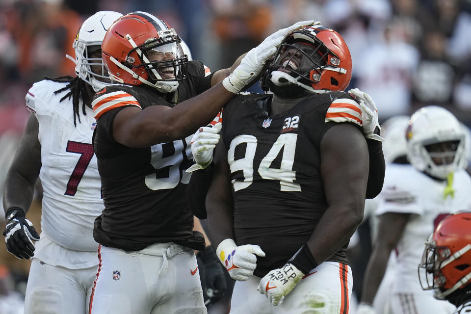Cleveland Browns defensive tackle Dalvin Tomlinson (94) is congratulated by defensive end Myles Garrett after sacking Arizona Cardinals quarterback Clayton Tune during the second half of an NFL football game Sunday, Nov. 5, 2023, in Cleveland. (AP Photo/Sue Ogrocki)