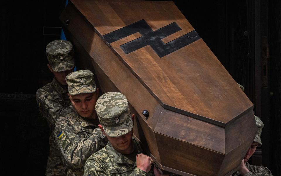 Ukrainian soldiers carry a coffin in Lviv during the funeral of Ukrainian servicemen Andriy Maltsev and Volodymyr Nestor, killed in combat - YURIY DYACHYSHYN/AFP