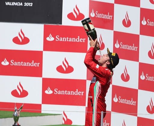 Ferrari's Spanish driver Fernando Alonso celebrates on the podium at the Valencia Street Circuit in Valencia after the European Formula One Grand Prix