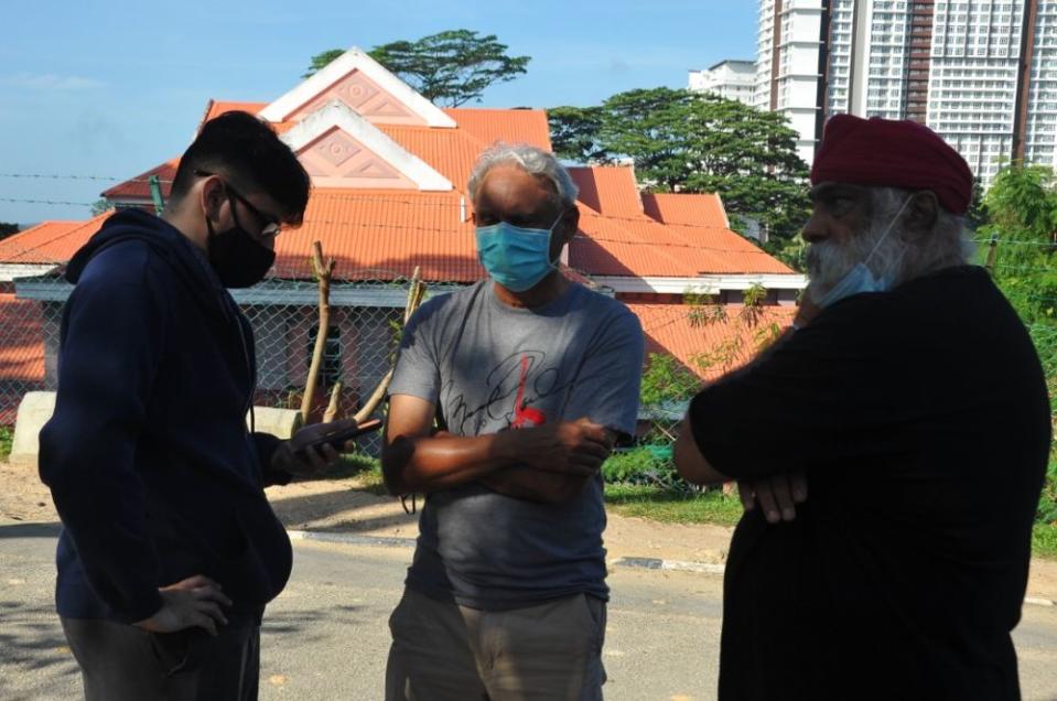 Serbegeth ‘Shebby’ Singh’s son Sonuljit Singh (left) with relatives at the Sultanah Aminah Hospital in Johor Baru January 13, 2022. — Picture by Ben Tan