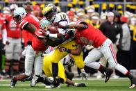 COLUMBUS, OH - NOVEMBER 24: Denard Robinson #16 of the Michigan Wolverines breaks through the tackle attempts by Travis Howard #7 of the Ohio State Buckeyes and Christian Bryant #2 of the Ohio State Buckeyes in the first half on his way to a 67-yard touchdown run at Ohio Stadium on November 24, 2012 in Columbus, Ohio. (Photo by Jamie Sabau/Getty Images)