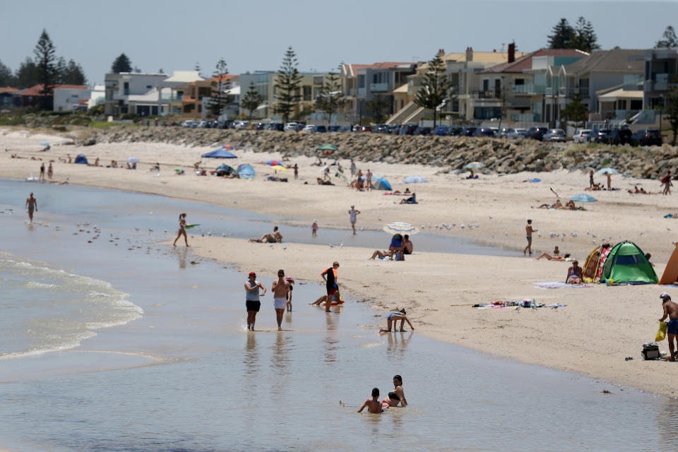 Beach goers cool off at Henley Beach during a hot day in Adelaide