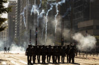 Police clash with anti-government demonstrators in Sao Paulo, Brazil, Sunday, May 31, 2020. Police used tear gas to disperse anti-government protesters in Brazil's largest city as they began to clash with small groups loyal to President Jair Bolsonaro. (AP Photo/Andre Penner)