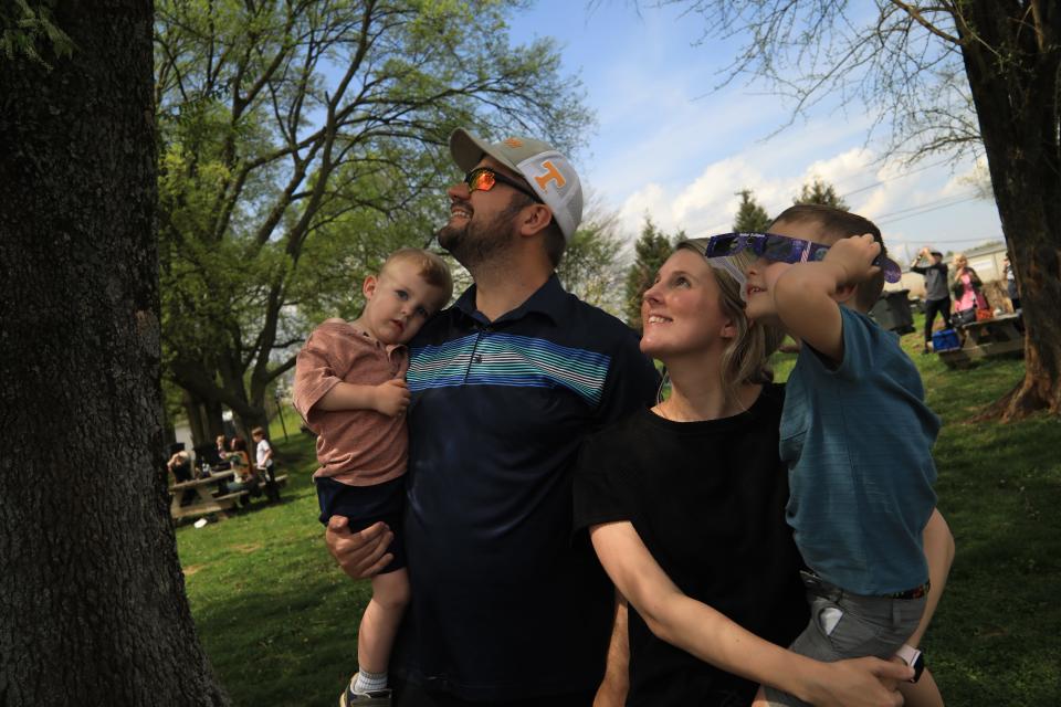 Son Henry, couple Johnathan and Amber and their son William Blick watch the solar eclipse at Beachaven on April 8, 2024 in Clarksville, Tenn. Johnathan and Amber, now parents of three, got engaged during 2017's total eclipse.