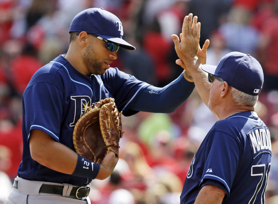 Tampa Bay Rays first baseman James Loney is congratulated by manager Joe Maddon, right, after the Rays defeated the Cincinnati Reds 1-0 in a baseball game, Saturday, April 12, 2014, in Cincinnati. Loney hit a home run to account for the only run of the game. (AP Photo/Al Behrman)