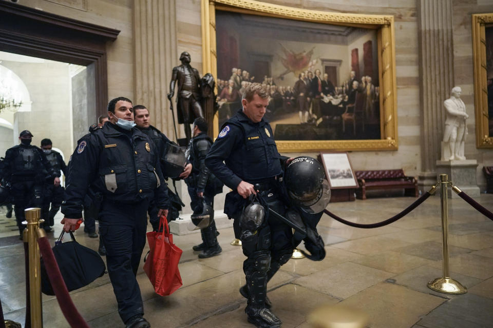 Members of the U.S. Capitol Police walk in the Rotunda of the U.S. Capitol after rioters loyal to President Donald Trump stormed the U.S. Capitol in Washington, Wednesday, Jan. 6, 2021. (AP Photo/J. Scott Applewhite)