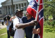 Ernest Branch (L) hugs a man carrying a Confederate flag (who didn't want to provide his name) saying, that he respects the fact the guy likes the flag but that he is against the flag flying on the Capitol grounds on June 23, 2015 in Columbia, South Carolina. The South Carolina governor Nikki Haley asked that the flag be removed afer debate over the flag flying on the capitol grounds was kicked off after nine people were shot and killed during a prayer meeting at the Emanuel African Methodist Episcopal Church in Charleston, South Carolina. (Photo by Joe Raedle/Getty Images)