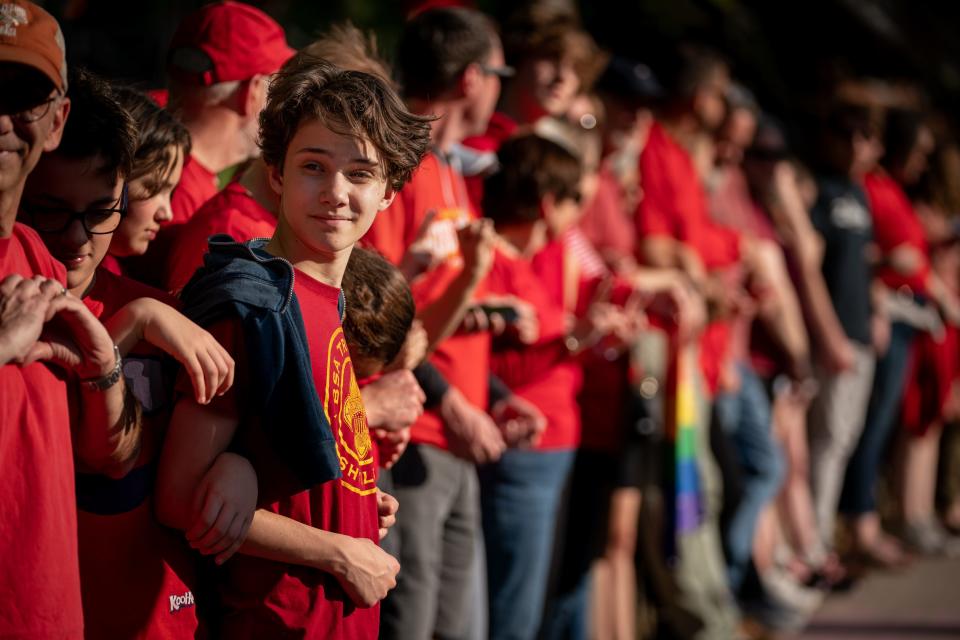 14-year-old Porter Rojas, left, and other demonstrators advocating for gun safety and common sense gun laws form a human chain along 21st Ave. S. in Nashville, Tenn., Tuesday, April 18, 2023.