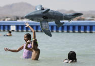 <p>Carolina Colon tosses a shark water toy airborne while cooling off at Spring Valley Lake in Victorville Calif., June 19, 2017. (James Quigg/The Daily Press via AP) </p>