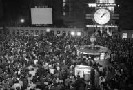 FILE - In this April 17, 1970 file photo, crowds watch a television screen in New York's Grand Central Station waiting for the safe arrival of the Apollo 13 astronauts in the Pacific Ocean. (AP Photo/J. Spencer Jones)