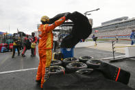 A crew member for driver Kyle Busch covers tires during a rain delay at a NASCAR Cup Series auto race at Charlotte Motor Speedway Sunday, May 24, 2020, in Concord, N.C. (AP Photo/Gerry Broome)