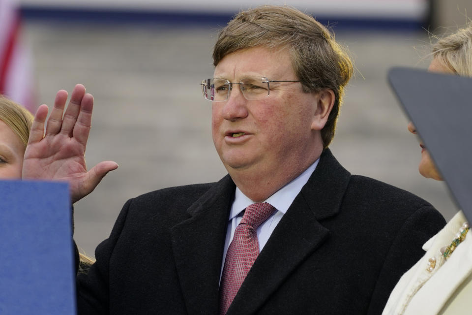 Mississippi Republican Gov. Tate Reeves recites the oath of office as he is sworn in to his second term, while his wife Elee Reeves, right, holds the family Bible during the inauguration ceremony in Jackson, Miss., Tuesday, Jan. 9, 2024. (AP Photo/Rogelio V. Solis)