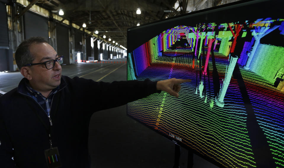 In this photograph taken on Monday, April 10, 2017, Luminar chief technology officer Jason Eichenholz points to a 3-D lidar map displayed on a screen in San Francisco. Luminar Technologies, a Silicon Valley startup, is trying to steer the rapidly expanding self-driving car industry in a new direction. Luminar kept its work closely guarded until Thursday, when the startup revealed the first details about a product Russell is touting as a far more powerful form of “lidar,” a key sensing technology used in autonomous vehicles designed by Google, Uber and major automakers. (AP Photo/Ben Margot)