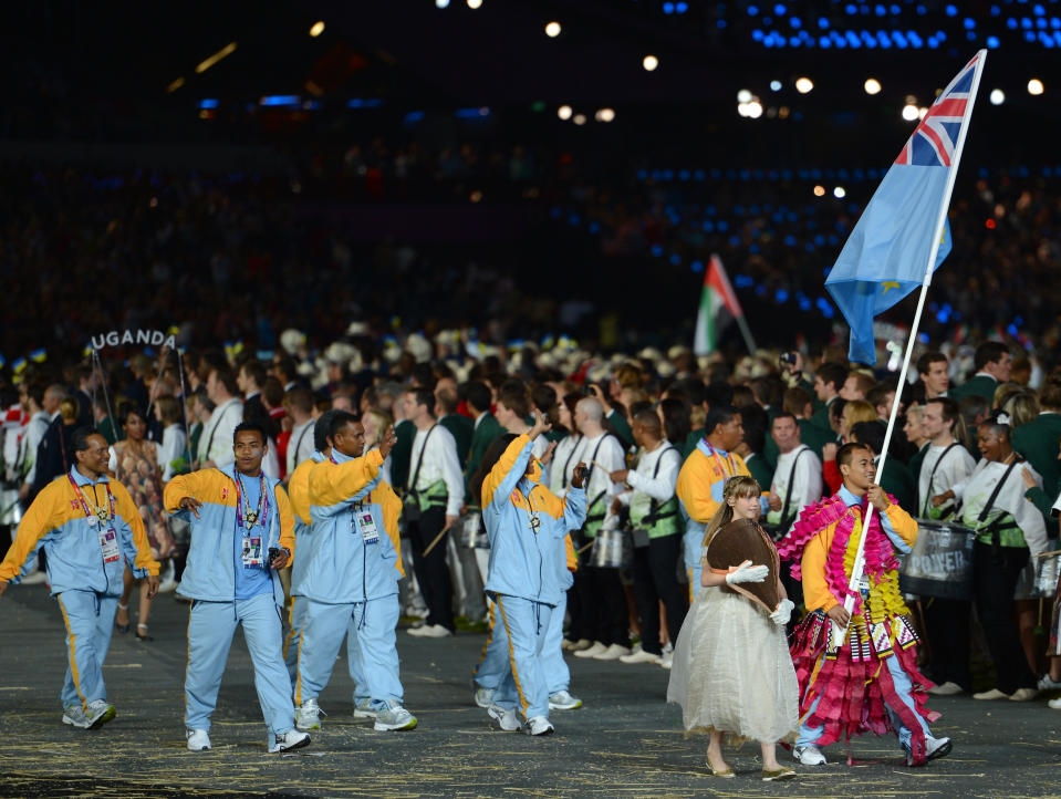 LONDON, ENGLAND - JULY 27: Tuau Lapua Lapua of the Tuvalu Olympic weightlifting team carries her country's flag during the Opening Ceremony of the London 2012 Olympic Games at the Olympic Stadium on July 27, 2012 in London, England. (Photo by Lars Baron/Getty Images)