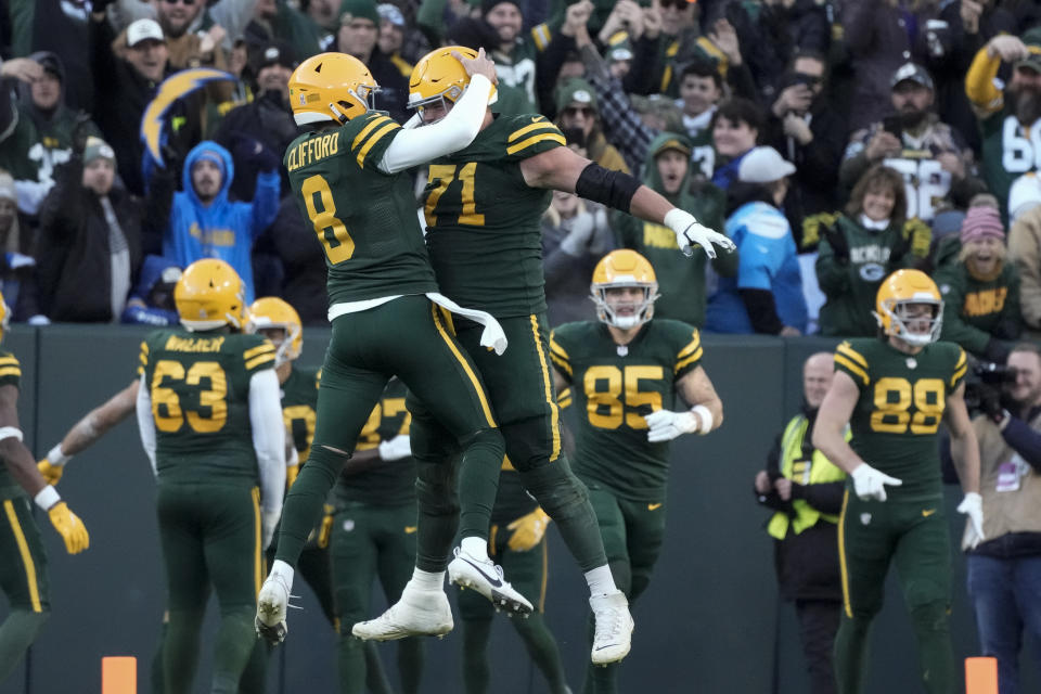 Green Bay Packers quarterback Sean Clifford (8) celebrate a touchdown catch by teammate wide receiver Romeo Doubs during the second half of an NFL football game against the Los Angeles Chargers, Sunday, Nov. 19, 2023, in Green Bay, Wis. (AP Photo/Morry Gash)