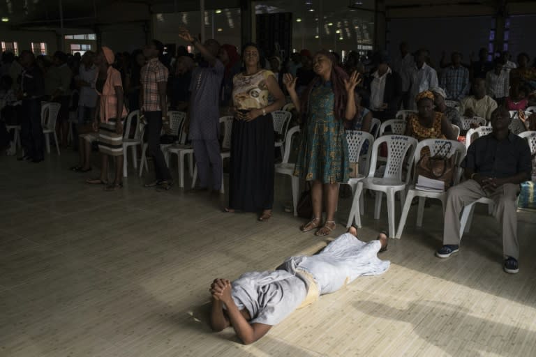 A woman lies on the ground during prayer at a “singles summit,” one of several offered by hugely popular Pentecostal churches in Nigeria