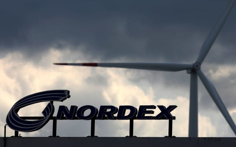 Dark clouds are gathering over the rotor blade plant of wind turbine manufacturer Nordex, a wind turbine on the company premises is turning. Bernd Wüstneck/dpa