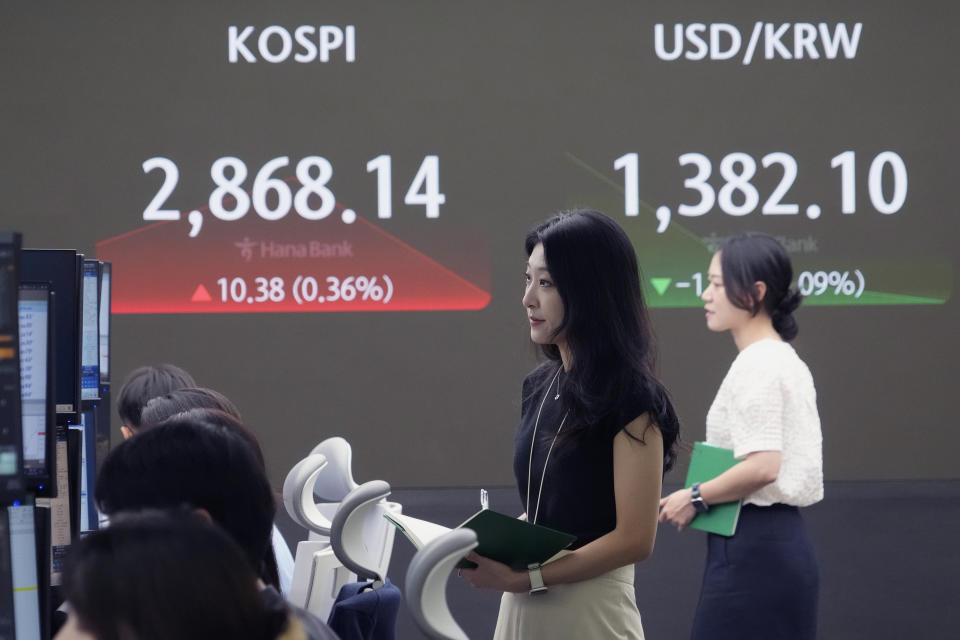 A currency trader watches monitors near the screen showing the Korea Composite Stock Price Index (KOSPI), left, and the foreign exchange rate between U.S. dollar and South Korean won at the foreign exchange dealing room of the KEB Hana Bank headquarters in Seoul, South Korea, Tuesday, July 9, 2024. (AP Photo/Ahn Young-joon)