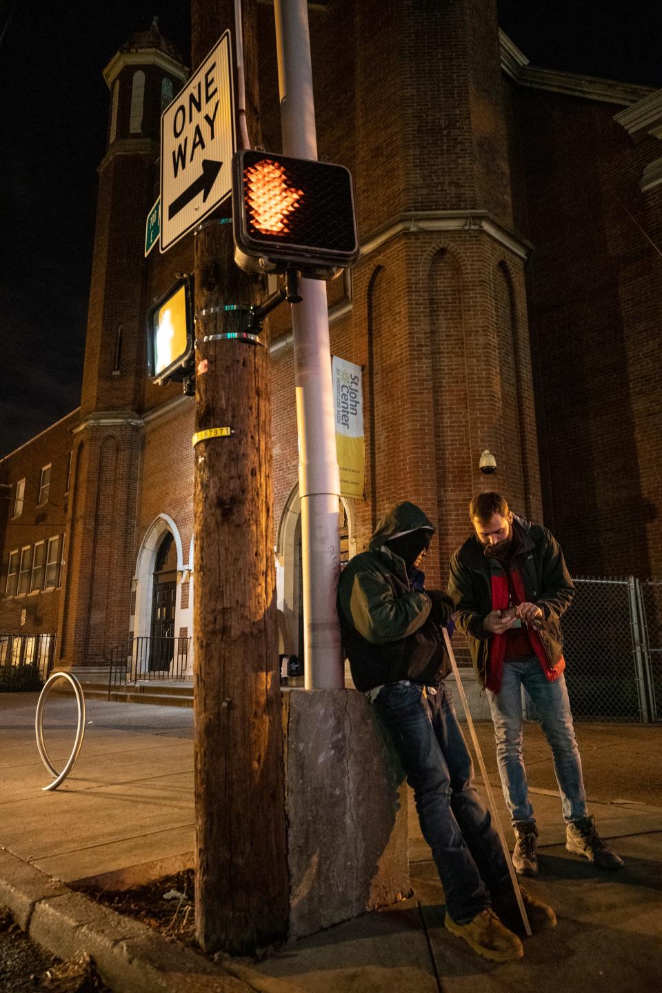 Joe Newland, left, a volunteer for Coalition for the Homeless' Street Count 2020 census, talks with a homeless man who was waiting for the St. John's Center to open. Jan. 30, 2020