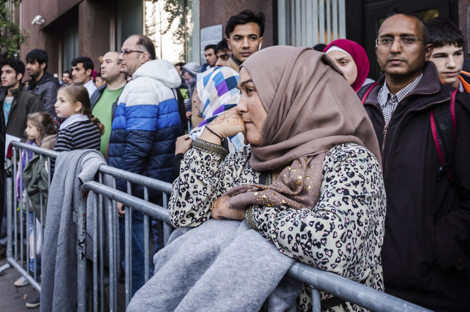 ARCHIVO - Refugiados esperan en fila ante la Oficina de Migración en Bruselas, el jueves 1 de octubre de 2015. Los países de la Unión Europea aprobaron el martes una amplia reforma del moribundo sistema de asilo del bloque mientras se aceleraba la campaña para las elecciones europeas del mes que viene, en las que se esperaba que la migración fuera un tema clave. (AP Foto/Geert Vanden Wijngaert, Archivo)