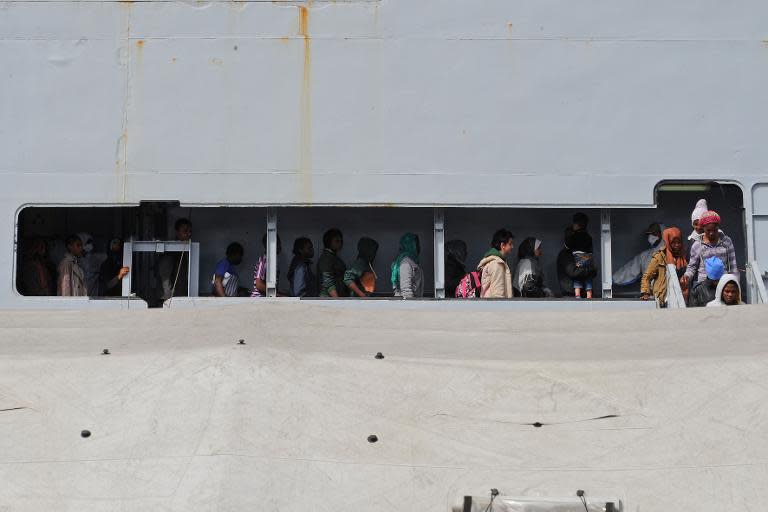 Women disembark from military ship "Bettica" as it arrives in the Italian port of Salerno after a naval operation on May 5, 2015