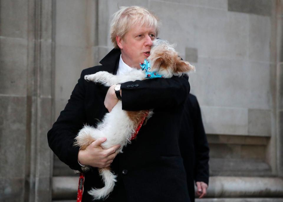 Britain’s Prime Minister and Conservative Party leader Boris Johnson holds his dog Dilyn as he leaves after voting in the general election at Methodist Central Hall, Westminster, London, Thursday, Dec. 12, 2019. (AP)