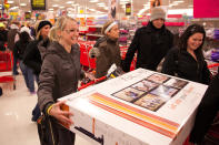 A joyful shopper laughs as she attempts to load a 40-inch TV into her cart at Target during their Black Friday sales event in Flint, Mich. on Thursday, Nov. 22, 2012. (AP Photo/Flint Journal, Griffin Moores)