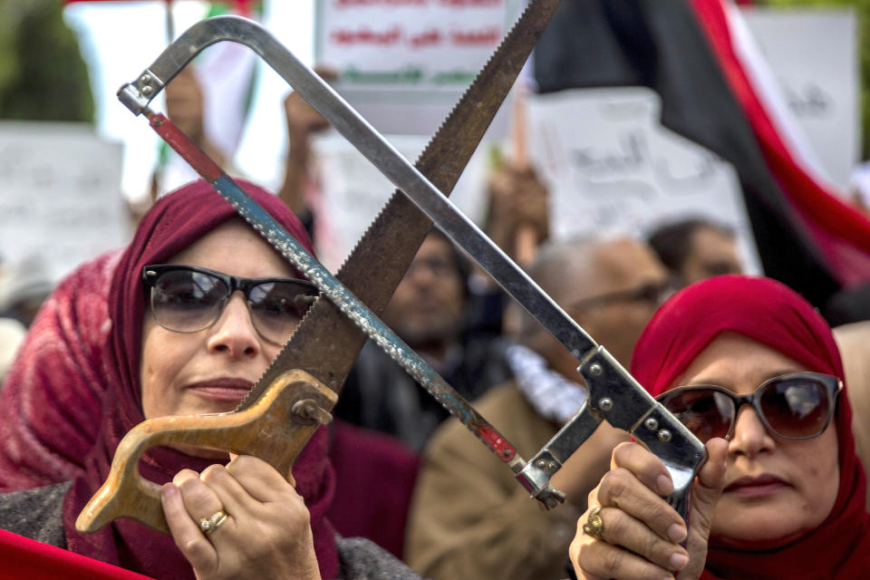 Tunisians demonstrate with saws Tuesday Nov.27, 2018 in Tunis. Amid international concern about the killing of Saudi journalist Jamal Khashoggi, some 200 protesters gathered in central Tunis on Monday night to protest the prince's Tuesday arrival for talks with the Tunisian president. (Hassene Dridi)