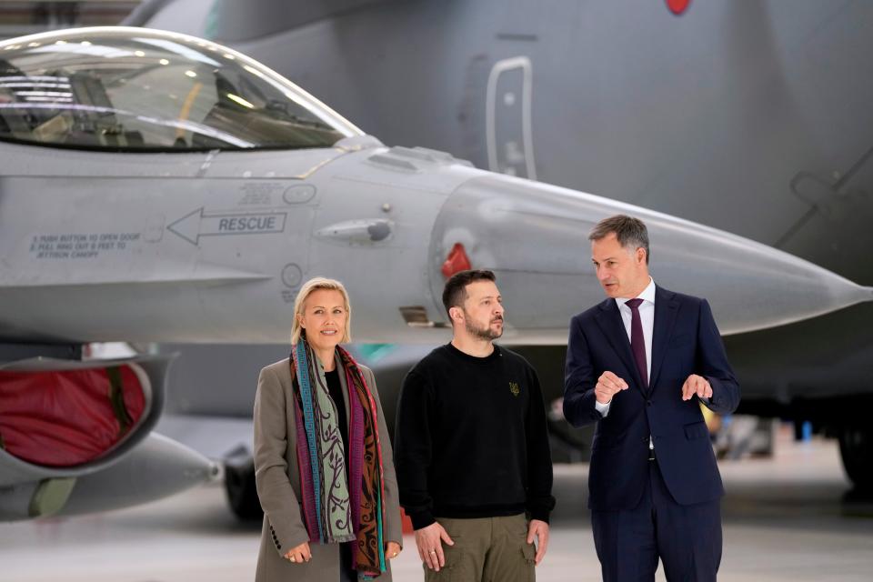 Belgium's Prime Minister Alexander De Croo, right, and Belgium's Defense Minister Ludivine Dedonder, left, pose with Ukraine's President Volodymyr Zelenskyy in front of an F-16 (AP)