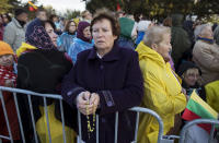 A woman prays as they wait for Pope Francis to arrive to celebrate a Mass in Confluence Park in Kaunas, Lithuania, Sunday, Sept. 23, 2018. Pope Francis is on the second of his two-day visit to Lithuania. (AP Photo/Mindaugas Kulbis)