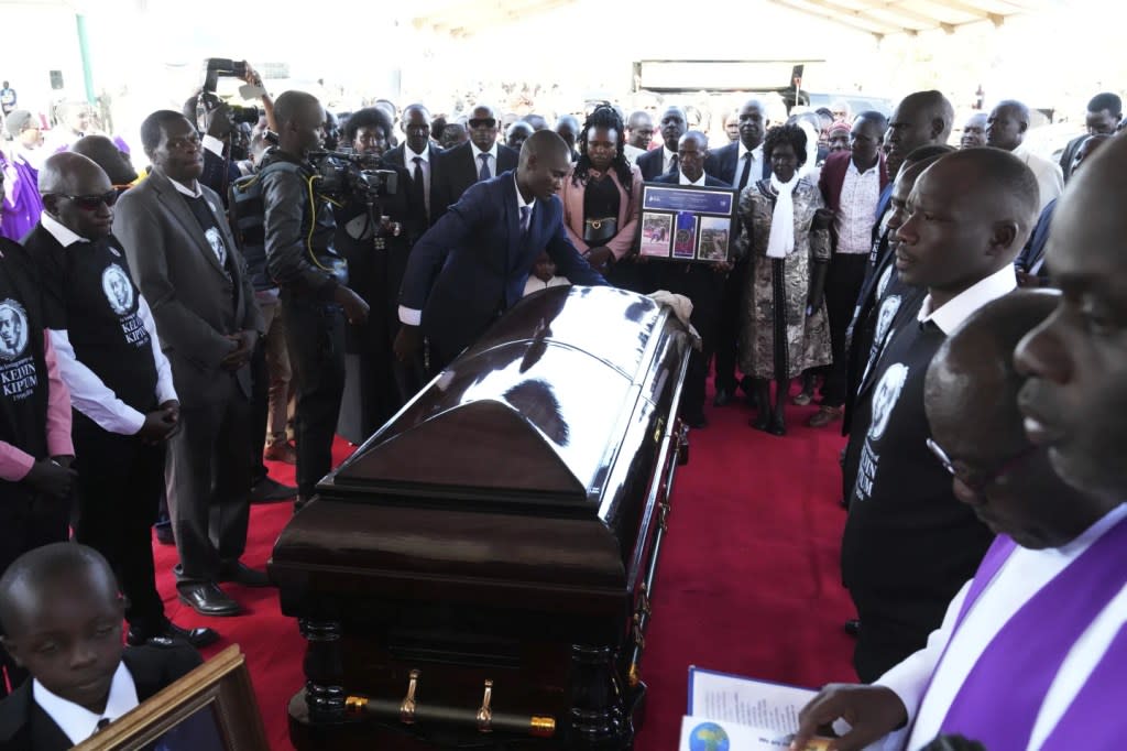 Family and friends gather around the coffin of marathon record holder Kelvin Kiptum ahead of his burial, in Elgeyo Marakwet, Kenya, Friday Feb. 23, 2024. (AP Photo/Brian Inganga)