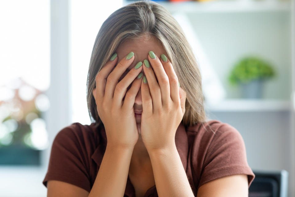 A woman covering her face with her hand