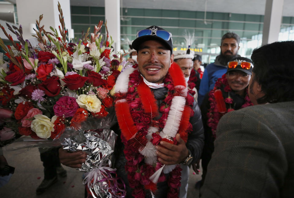 Nepalese climber Nirmal Purja, center, and his team, who recently made history by scaling the K2 summit in the winter season, are greeted by local tour operators upon their arrival at airport in Islamabad, Pakistan, Thursday, Jan. 21, 2021. Winter winds on K2 can blow at more than 200 km per hour (125 miles per hour) and temperatures can drop to minus 60 C (minus 76 F), an official of Pakistan's Alpine Club, Karrar Haideri said. (AP Photo/Anjum Naveed)