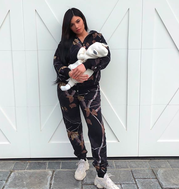 Kylie was dressed in a two-piece tracksuit and also rocking a pair of Yeezy trainers while she held her baby daughter. Source: Instagram / kyliejenner