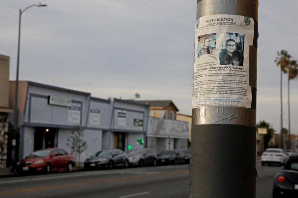 A Los Angeles Police Department missing person flyer hangs is taped to a post.