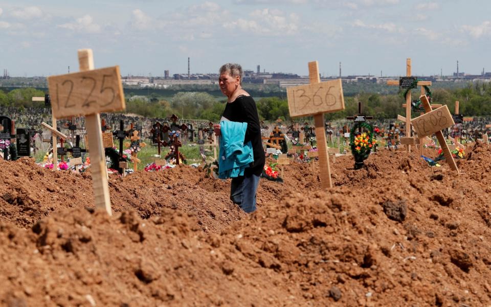 A woman walks at a cemetery in search of her relative's grave outside Mariupol - Alexander Ermochenko/REUTERS