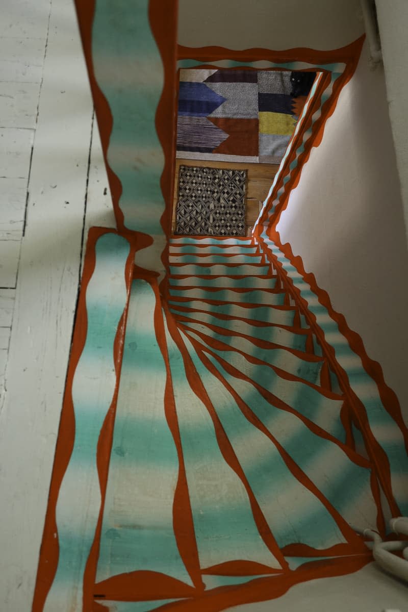 view of colorful patterned stairs from top floor