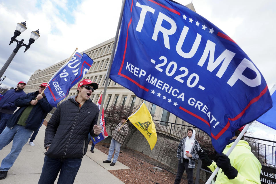 Max Versluys stands outside the Richard H. Austin state office building during a rally in Lansing, Mich., Saturday, Nov. 14, 2020. Michigan's elections board is meeting to certify the state's presidential election results. (AP Photo/Paul Sancya)