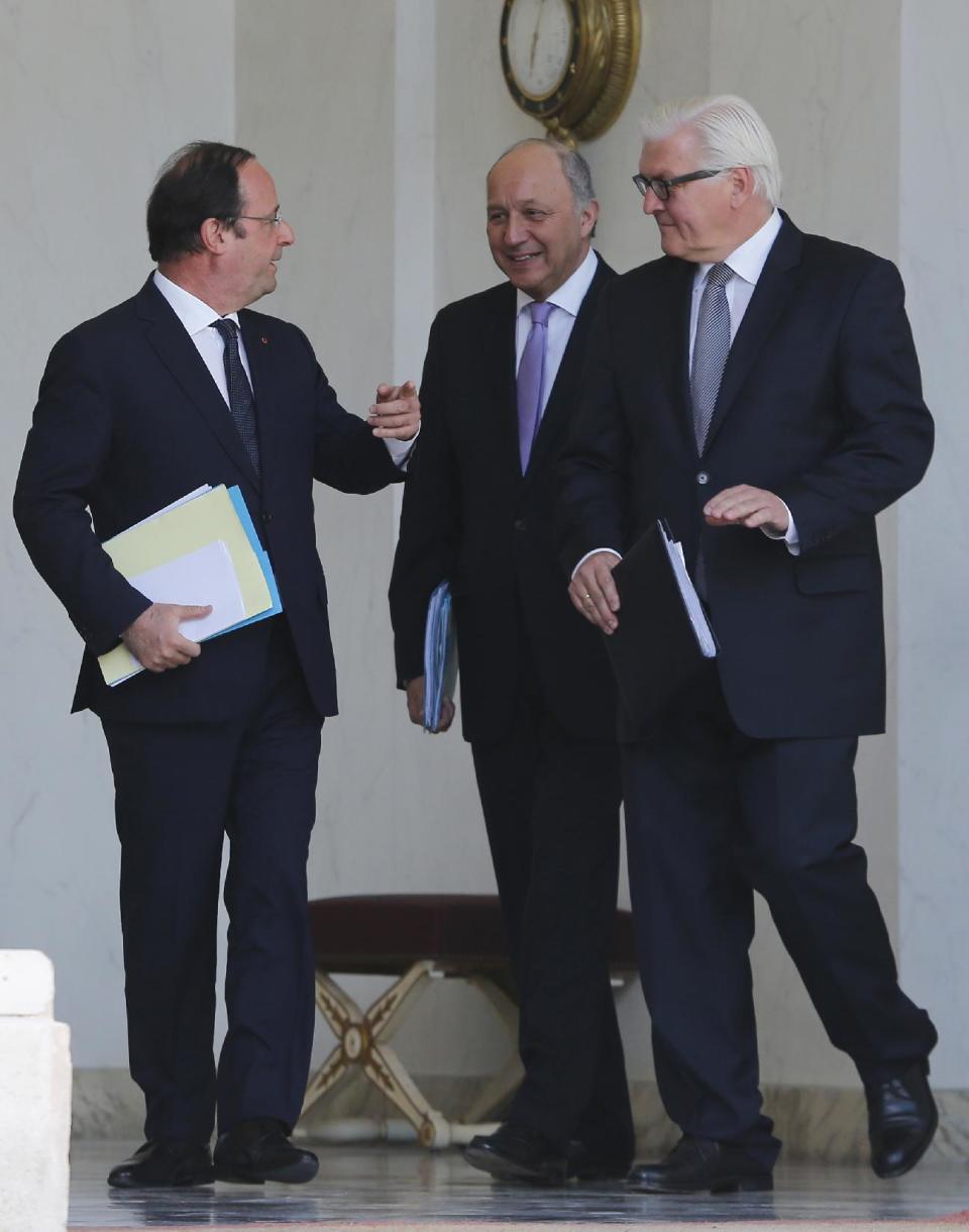 French President Francois Hollande, left, talks to German Foreign Minister Frank-Walter Steinmeier,right, and French Foreign Minister Laurent Fabius at the end of the weekly Cabinet meeting in the Elysee Palace in Paris. Wednesday, May 14, 2014.(AP Photo/Jacques Brinon)