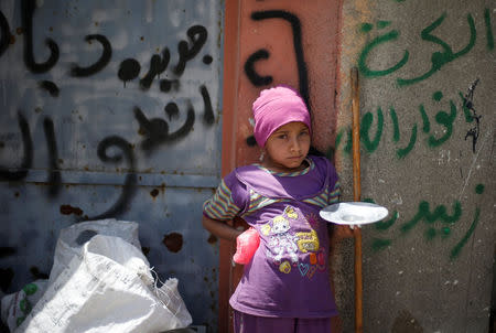 A girl waits to receive food at a distribution point after the end of the battles between the Iraqi forces and Islamic State militants at Tayaran district in western Mosul, Iraq, April 30, 2017. REUTERS/Muhammad Hamed