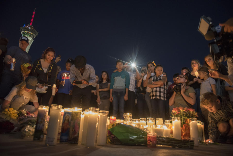 Mourners place candles and flowers down on the ground during the vigil.&nbsp;