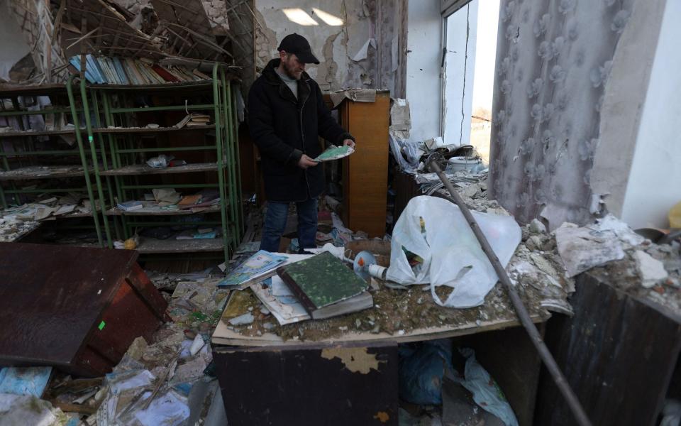 Ukrainian teacher Oleksandr Pogoryelov, 45, stands in his former school, destroyed in April 2022 - ANATOLII STEPANOV/AFP