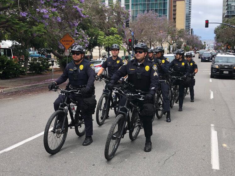 San Diego police quietly trail protesters at a distance on the streets of Saturday's march.