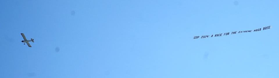 An airplane flies with a banner above Fiserv Forum before the Republican presidential debate in Milwaukee on Wednesday.