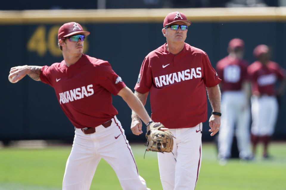 Arkansas NCAA college baseball coach Dave Van Horn, right, follows team practice at TD Ameritrade Park, as Casey Martin throws in Omaha, Neb., Friday, June 14, 2019. Arkansas opens College World Series play Saturday night against Florida State, which will be trying to win retiring coach and NCAA all-time wins leader Mike Martin's first national championship in his 17 visits to Omaha. (AP Photo/Nati Harnik)