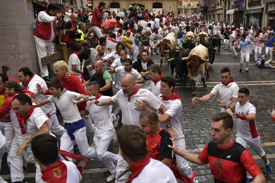 <p>Revellers run next to fighting bulls from the Victoriano del Rio ranch during the 6th day of the running of the bulls at the San Fermin Festival in Pamplona, northern Spain, July 12, 2018. (Photo: Alvaro Barrientos/AP) </p>