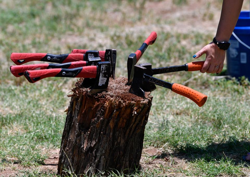 Axes rest on a stump at an event hosting vendor Abilene Axe Company in June 2019. Once an axe-throwing trailer, the business has expanded and now plans to open its new location in the soDA district on Thursday.